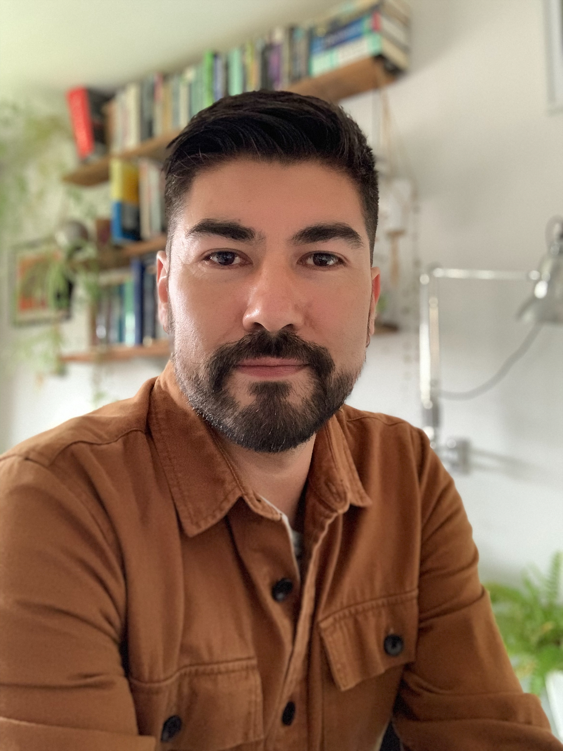 Portrait photo of Luis Carabantes wearing a brown shirt and looking at the camera.