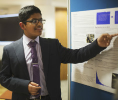 Student presenting a poster at Cosmic Con