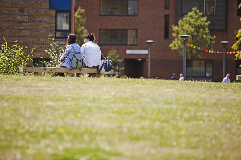 Two students sitting on a park bench