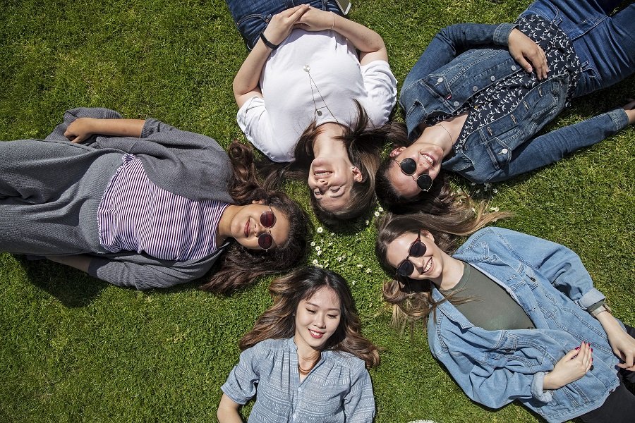 Queen Mary Summer School Students lying in the sun on the grass