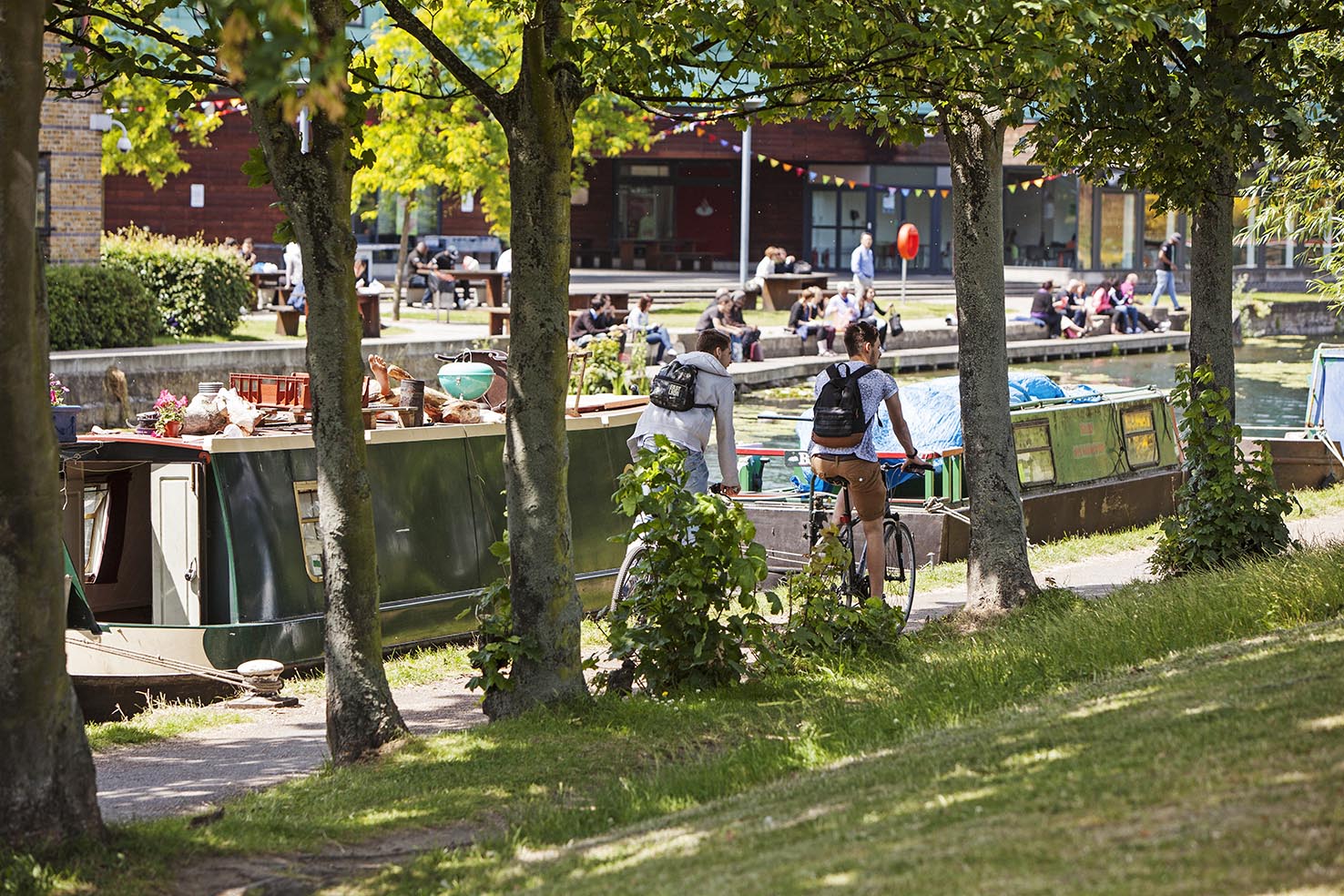 Students riding by the canal at the QMUL Mile End campus