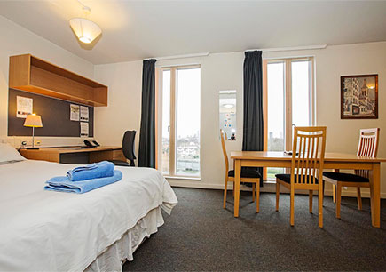View of a typical studio flat at Queen Mary with bed, desk and table.