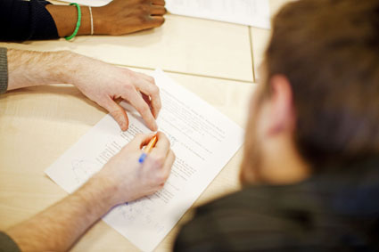 Zoom in of someone writing on a piece of paper