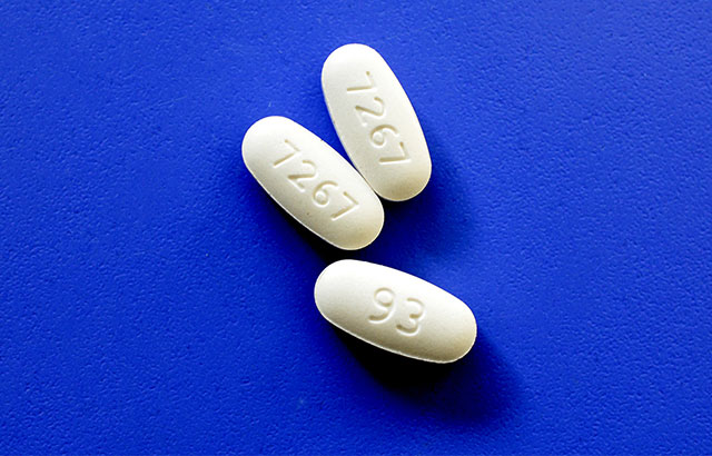 Metformine prescription pills with identification numbers on blue background