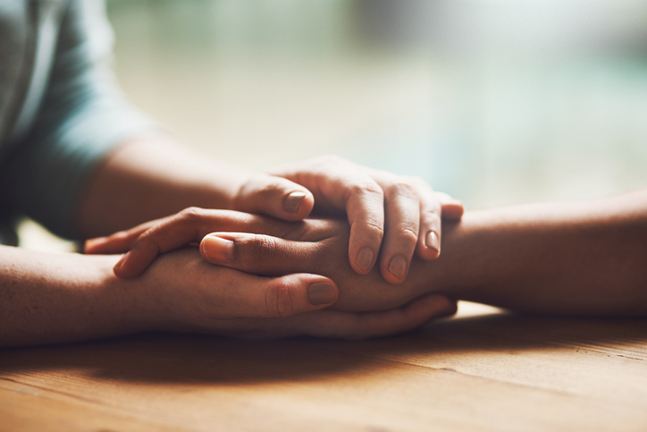 Hands of two people clasped together