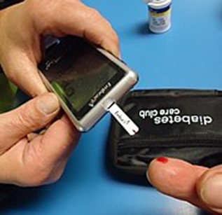 A person uses a fingertip prick test to check their blood glucose levels.