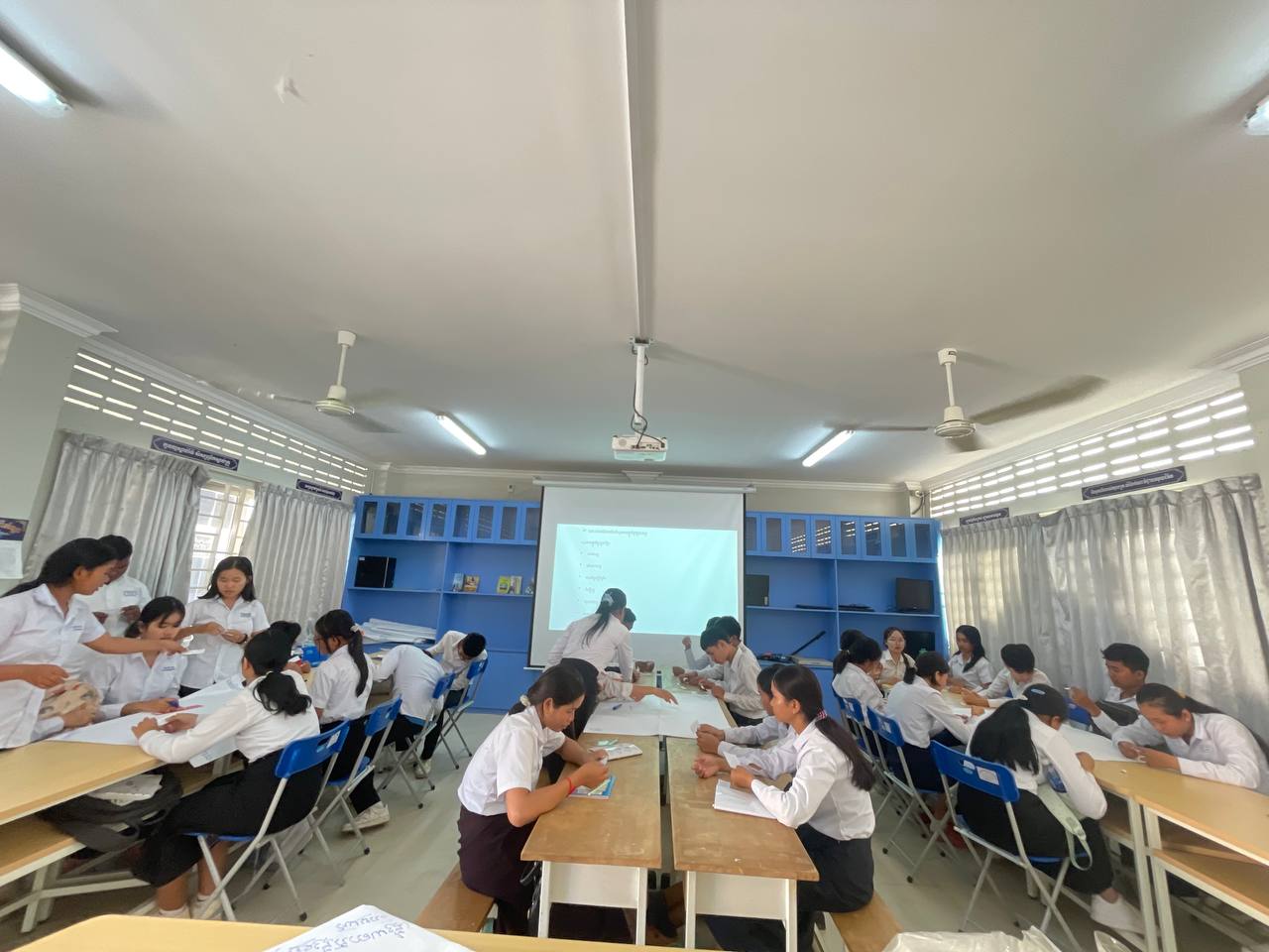 students working in a classroom in front of a screen