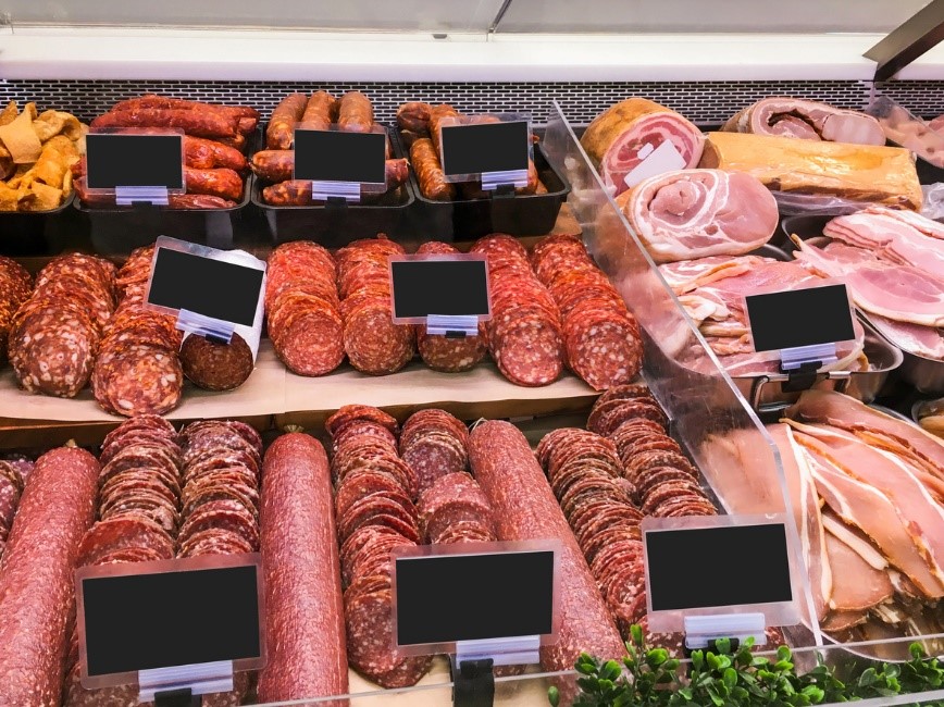 A selection of sausages and cold meats on display in a supermarket